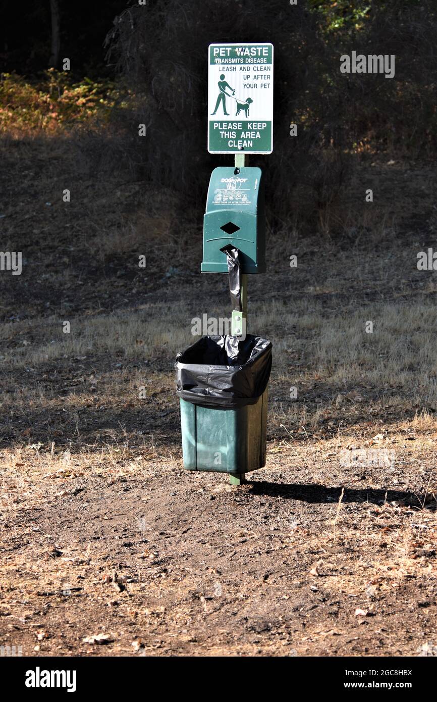 Stazione pubblica di rifiuti per animali domestici per ottenere sacchetti di plastica e poi mettere il doo cane in un cestino dopo che il critter fa la sua cosa sui sentieri della parte Foto Stock