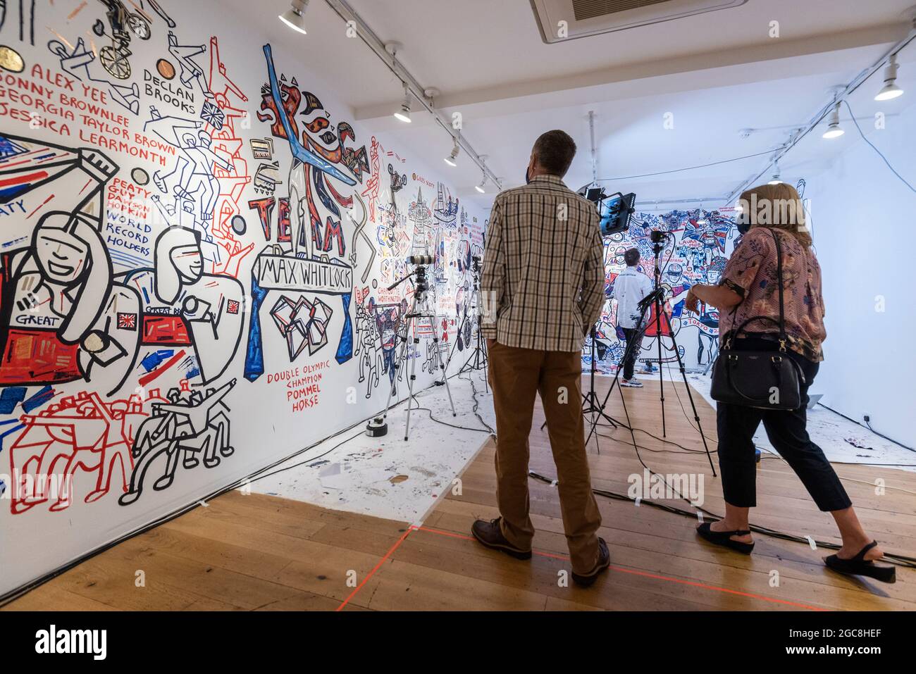 Londra, Regno Unito. 7 agosto 2021. I visitatori possono vedere il murale di ben Mosley incentrato sul successo degli atleti del Team Great Britain (GB) alle Olimpiadi di Tokyo 2020. Basato al pop-up Team GB Studio di Carnaby Street, l'artista aggiorna il suo murale quotidiano con i successi degli atleti. Gli eventi dell'ultimo giorno e la cerimonia di chiusura sono gli unici lavori rimasti. Team GB è diventato il primo ad adottare gettoni non fungibili (NFT) con i risultati precedenti degli atleti, che possono essere acquistati attraverso un negozio dedicato. Credit: Stephen Chung / Alamy Live News Foto Stock