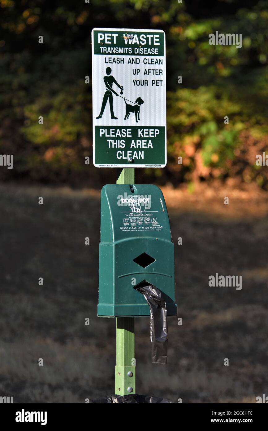 Stazione pubblica di rifiuti per animali domestici per ottenere sacchetti di plastica e poi mettere il doo cane in un cestino dopo che il critter fa la sua cosa sui sentieri della parte Foto Stock