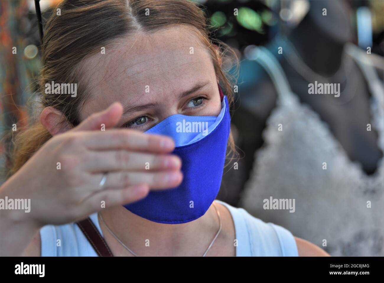 Giovane donna che indossa una maschera in una vendita pubblica di strada nel nord della California durante la recente ripresa di infezioni Corona-19 Foto Stock