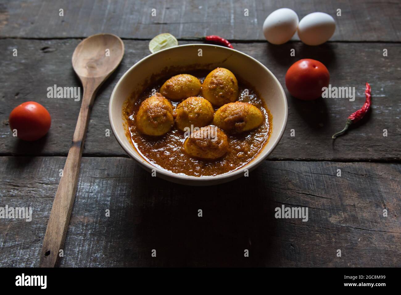 Primo piano di masala d'uovo o curry d'uovo preparato con cipolla, aglio e una miscela di spezie indiane in un recipiente. Foto Stock