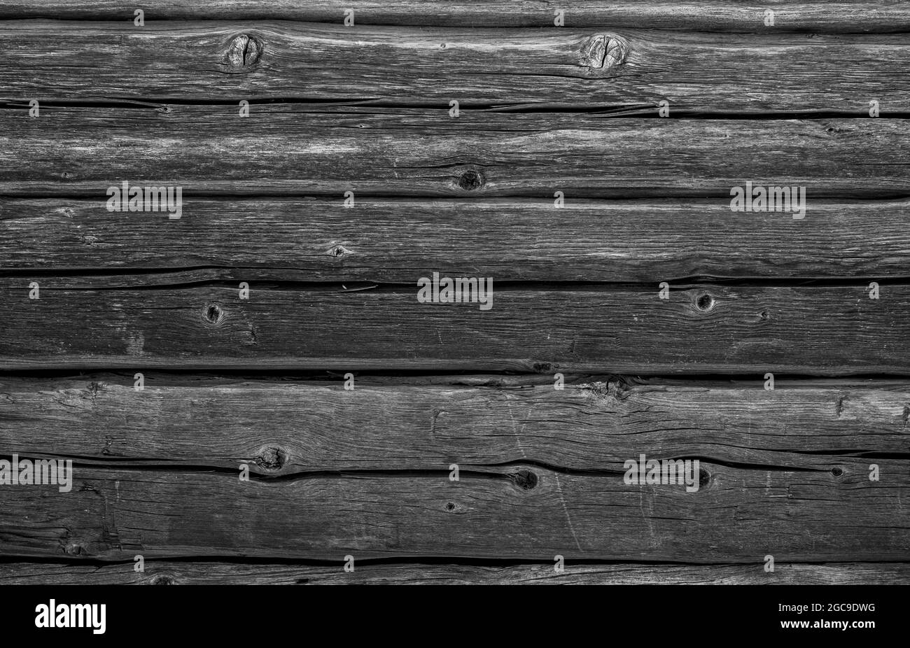 Vista frontale di un vecchio muro di legno, stagionato e invecchiato, in bianco e nero. Sfondo con texture a frame completo astratto. Foto Stock
