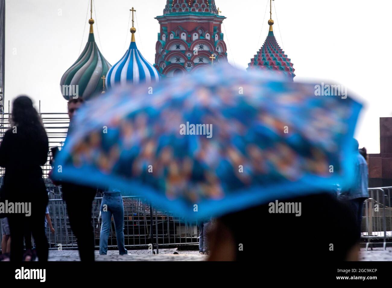 Mosca, Russia. 7 agosto 2021 tempo piovoso a Mosca. Una donna con un ombrello cammina sulla Piazza Rossa sullo sfondo della Cattedrale di San Basilio nel centro di Mosca, Russia Foto Stock