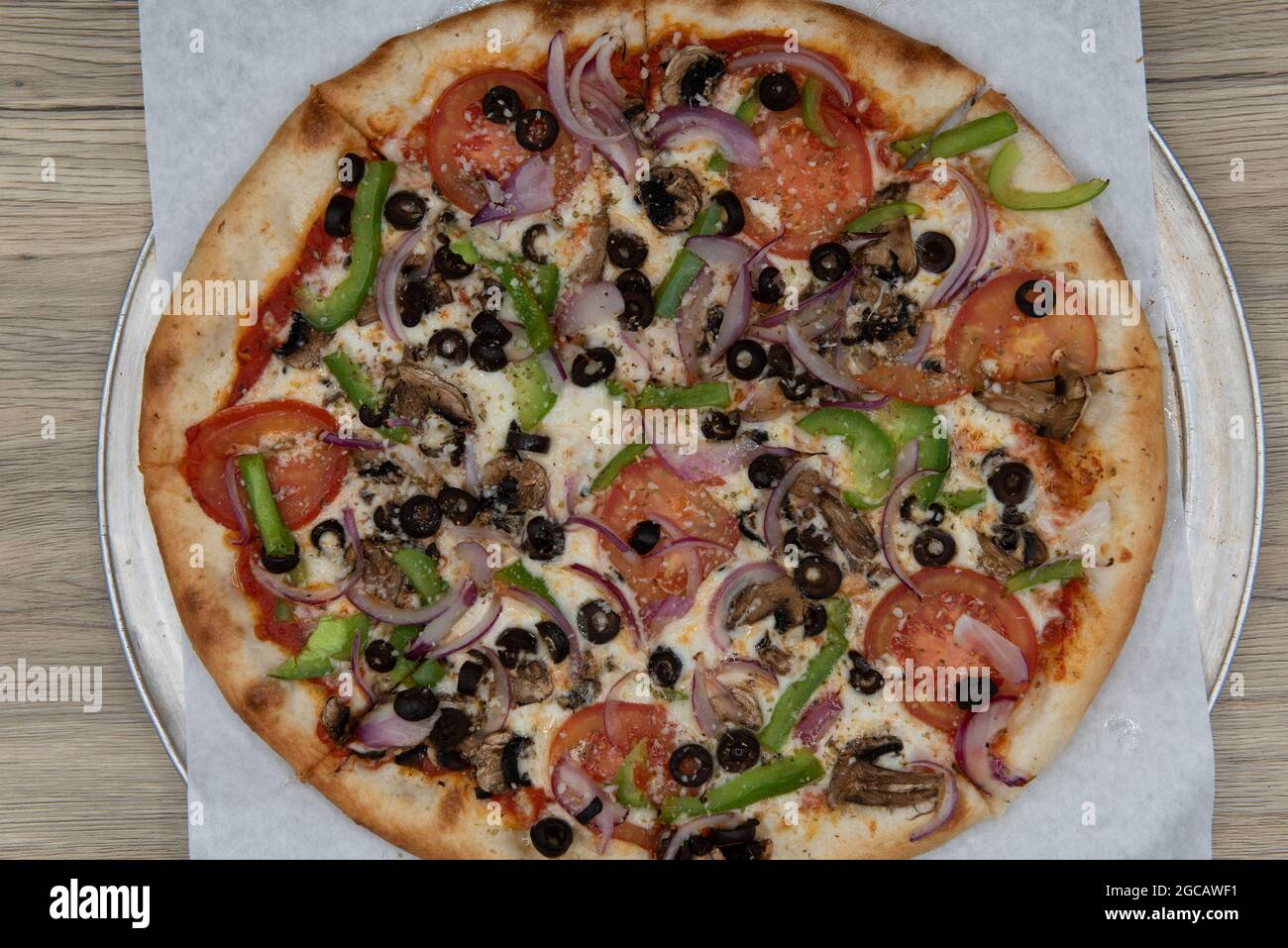 Vista dall'alto della pizza vegetariana con farciture di verdure e crosta croccante per un pasto completo in famiglia. Foto Stock