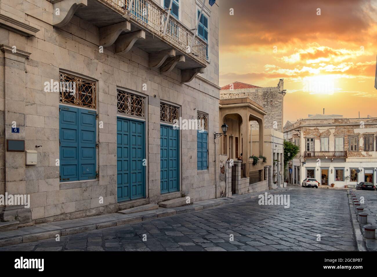 Isola di Syros, Cicladi, Grecia. Tramonto colorato su edifici neoclassici tradizionali nella capitale di Siros Hermoupolis. Strade acciottolate vuote somma Foto Stock