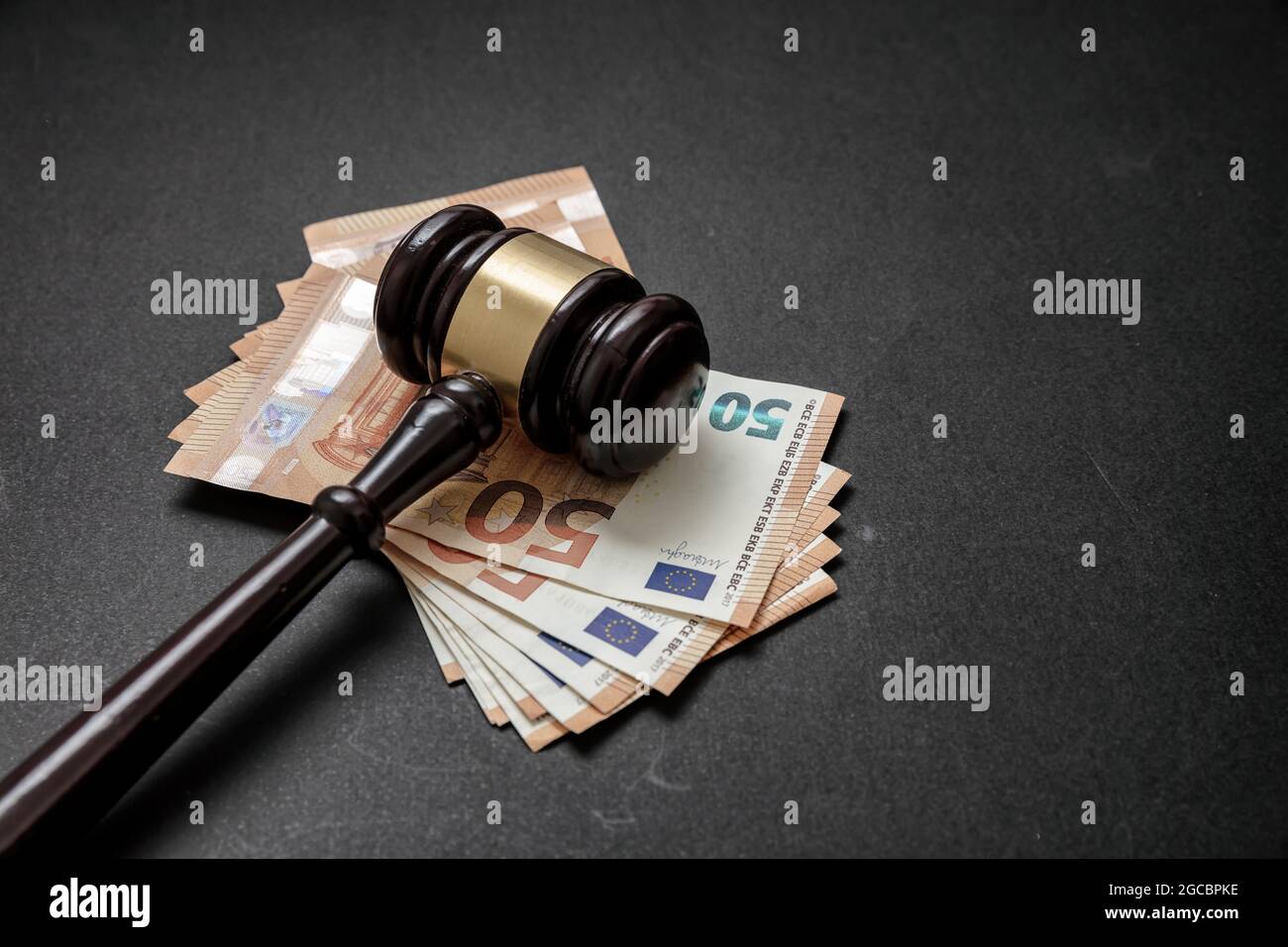 Giudice o asta gavel e banconote in euro su sfondo nero. Tangente, concetto di criminalità finanziaria. Spazio di copia, modello Foto Stock