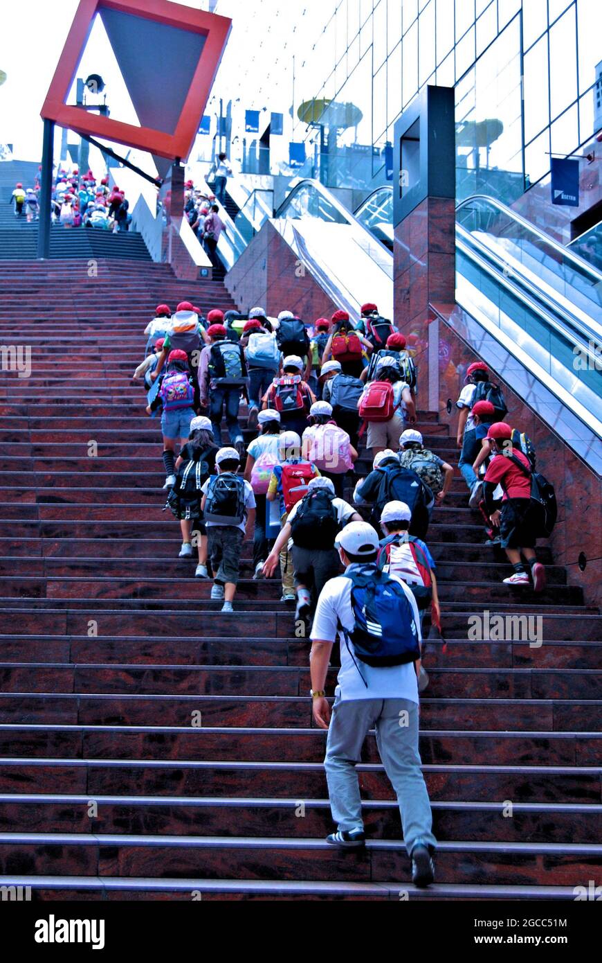 Bambini a scuola che si arrampicano sulla Grande scalinata della Stazione di Kyoto che conduce allo Sky Garden al 15.o piano, alla Stazione di Kyoto, Kyoto, Giappone Foto Stock