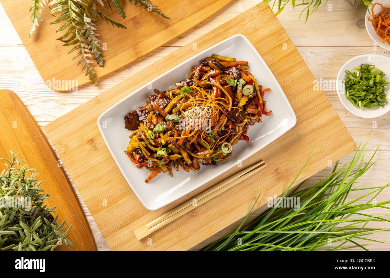 Piatto di maiale mescolato fritto con tagliatelle e verdure Foto Stock