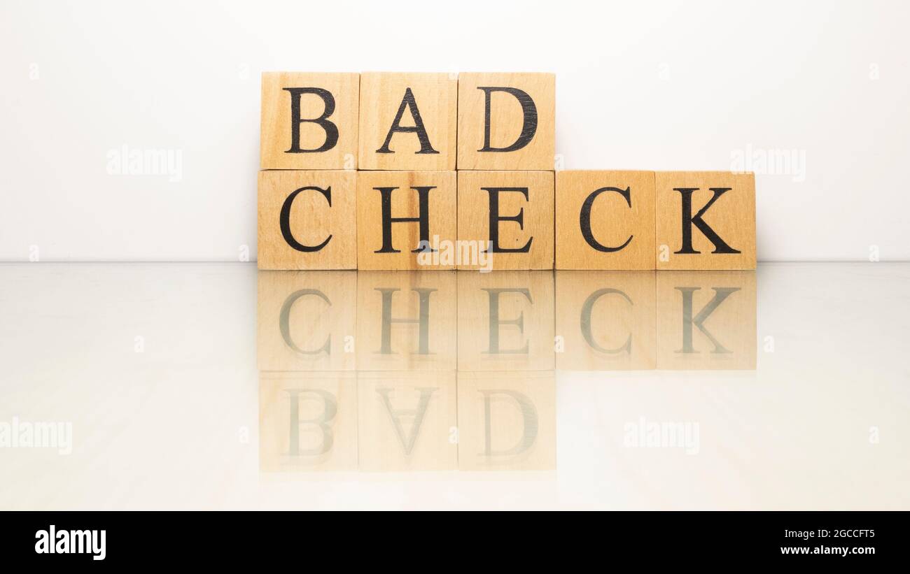 Il nome Bad check è stato creato da cubi di legno lettera. Finanza ed economia. Primo piano. Foto Stock