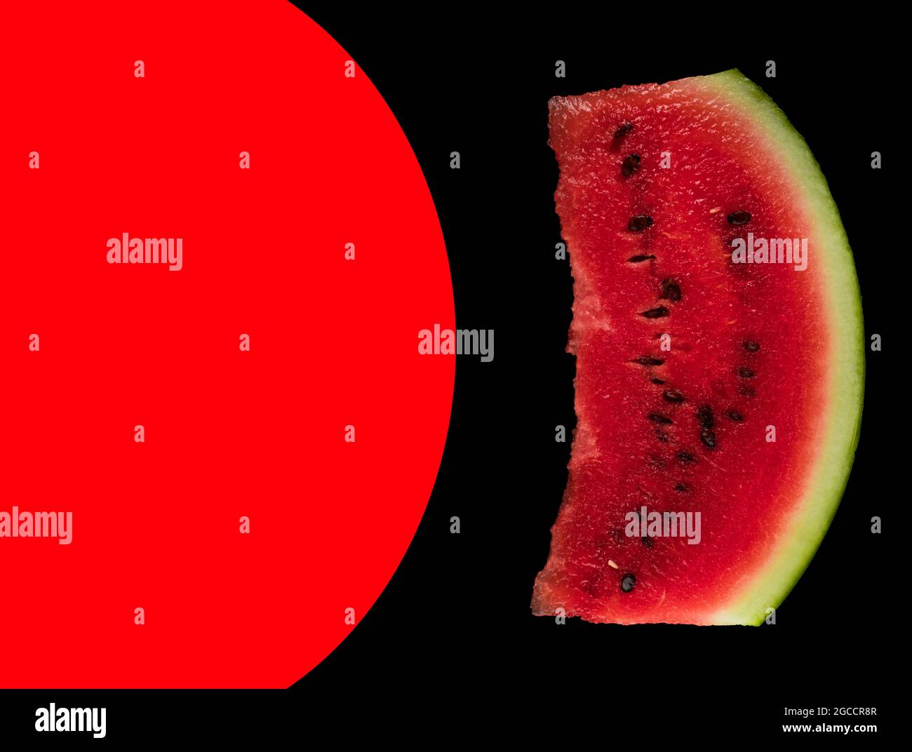 Nella foto, un pezzo di cocomero maturo su sfondo nero e un posto per il testo, evidenziato in rosso Foto Stock