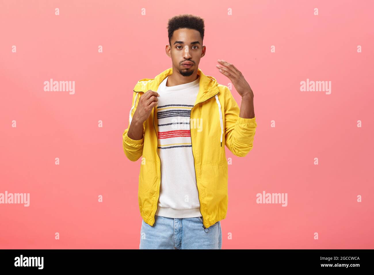 Ragazzo vestito in modo inappropriato per il tempo caldo sudare respirare e fare vento con palmo scosso per raffreddare giù il collare di t-shirt mentre Foto Stock