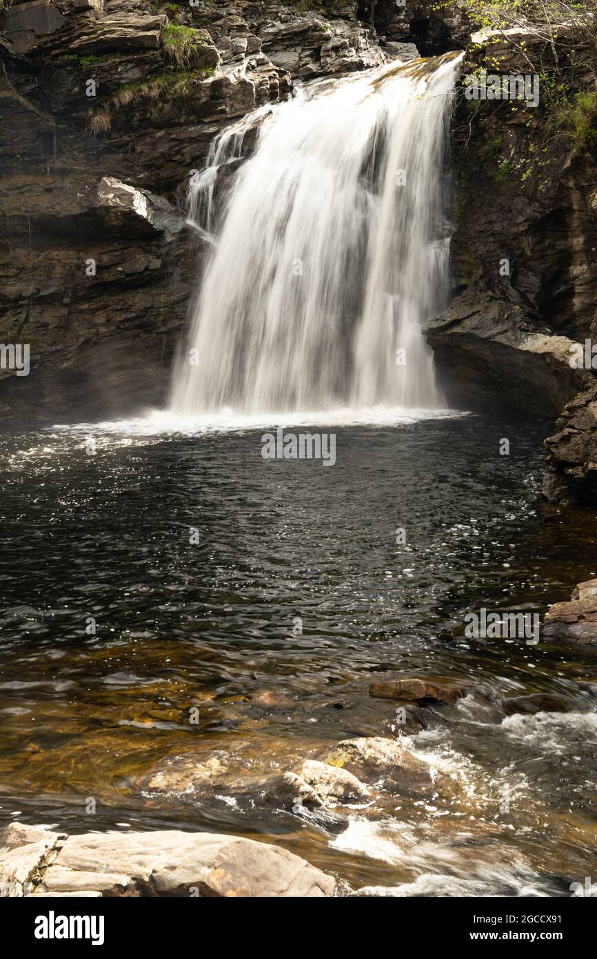 Cascata che scorre su sporgenze rocciose nella tranquilla piscina dell'isola scozzese Foto Stock