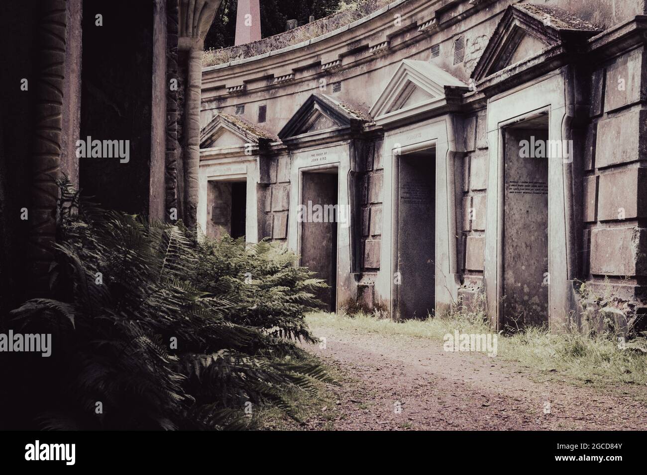 Mausoleo del cimitero vittoriano con architettura classica e vegetazione ricoperta Foto Stock