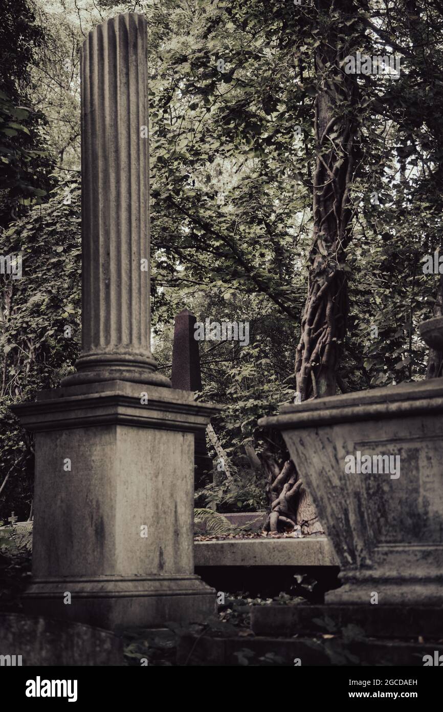 Monumenti del cimitero vittoriano con colonne classiche tra alberi maturi a Highgate Foto Stock