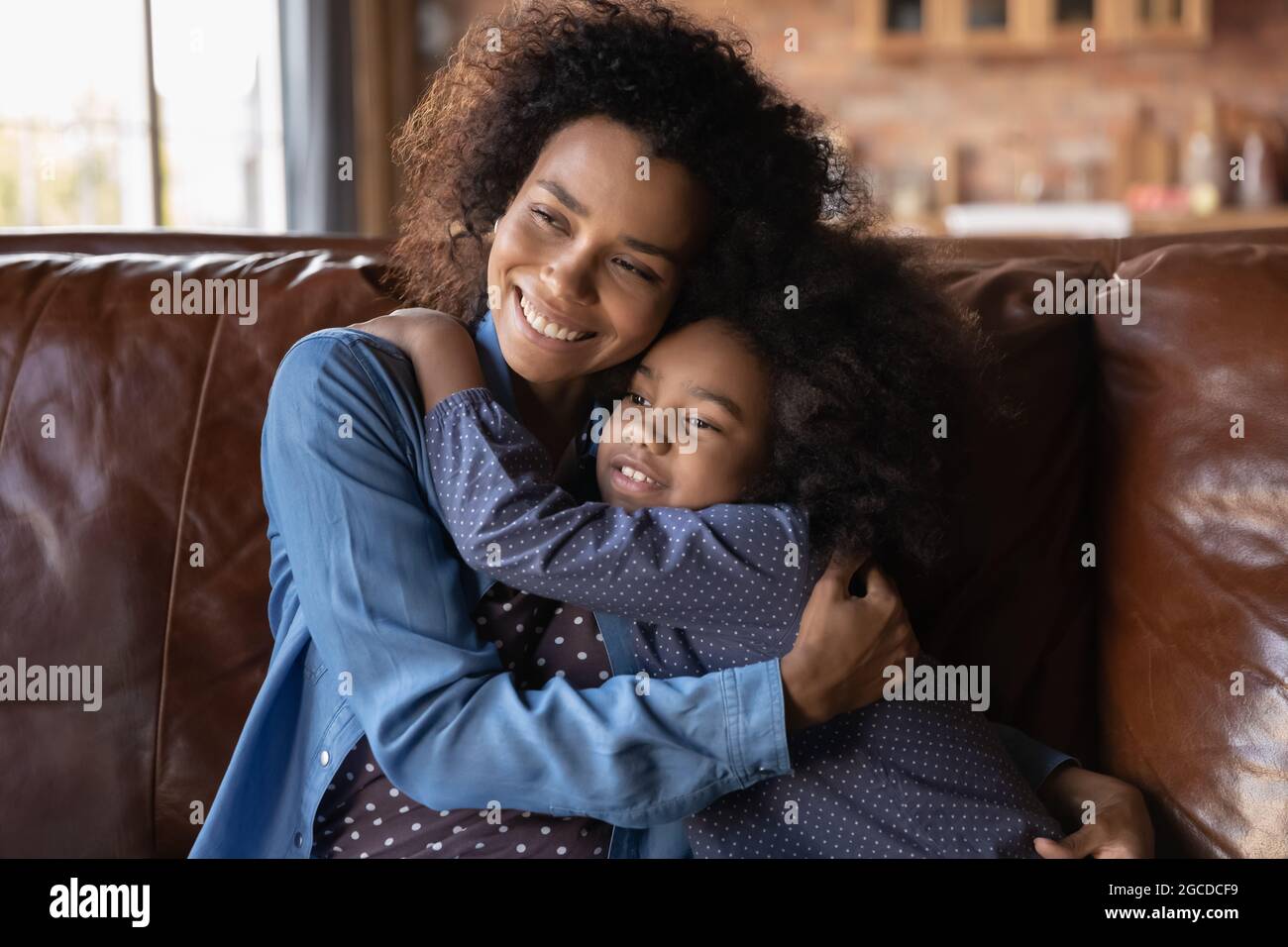 Amando mamma biraciale e figlia adolescente abbraccio e coccole Foto Stock