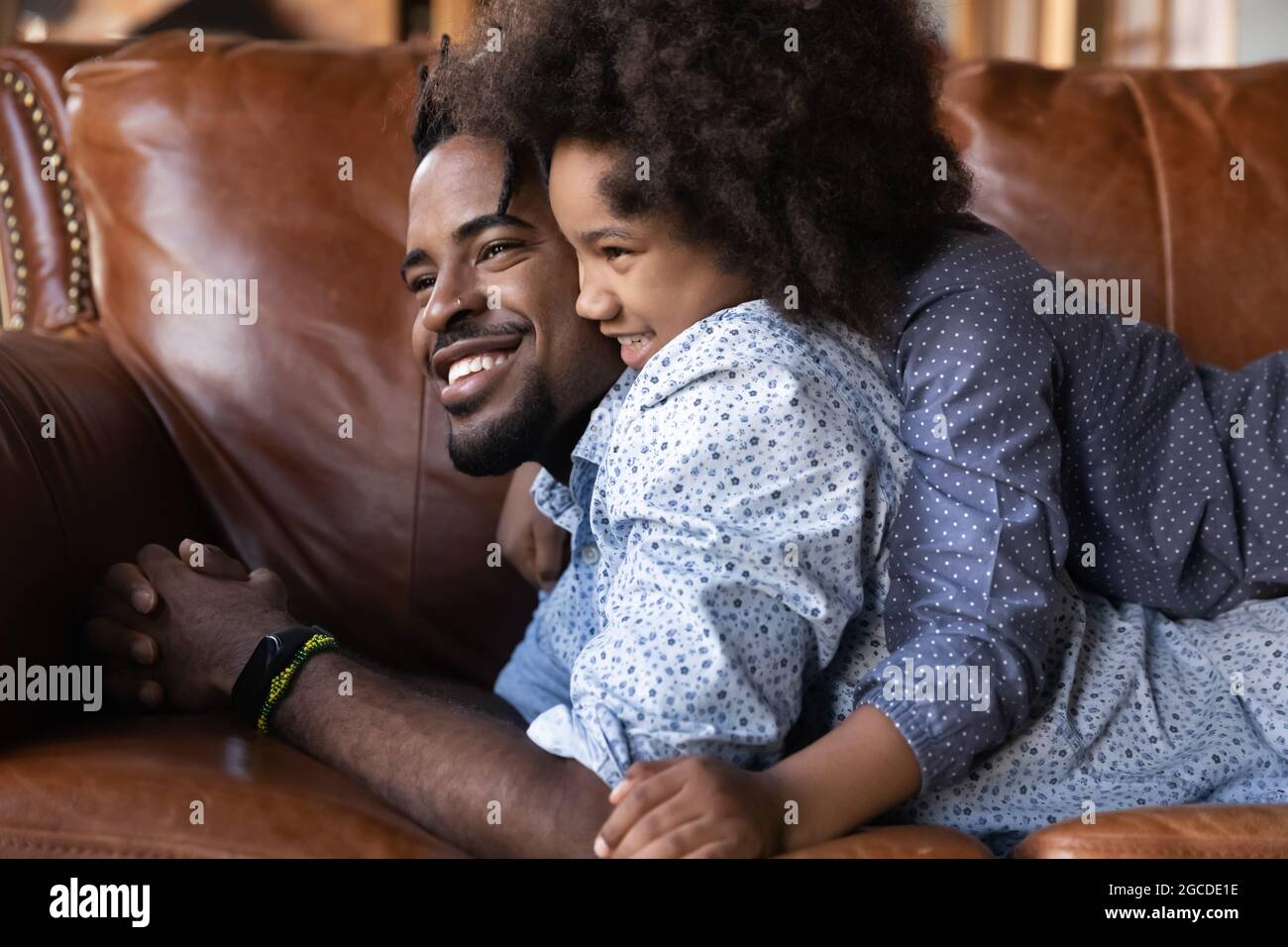 Felice etnia padre e teen figlia rilassarsi a casa hugging Foto Stock