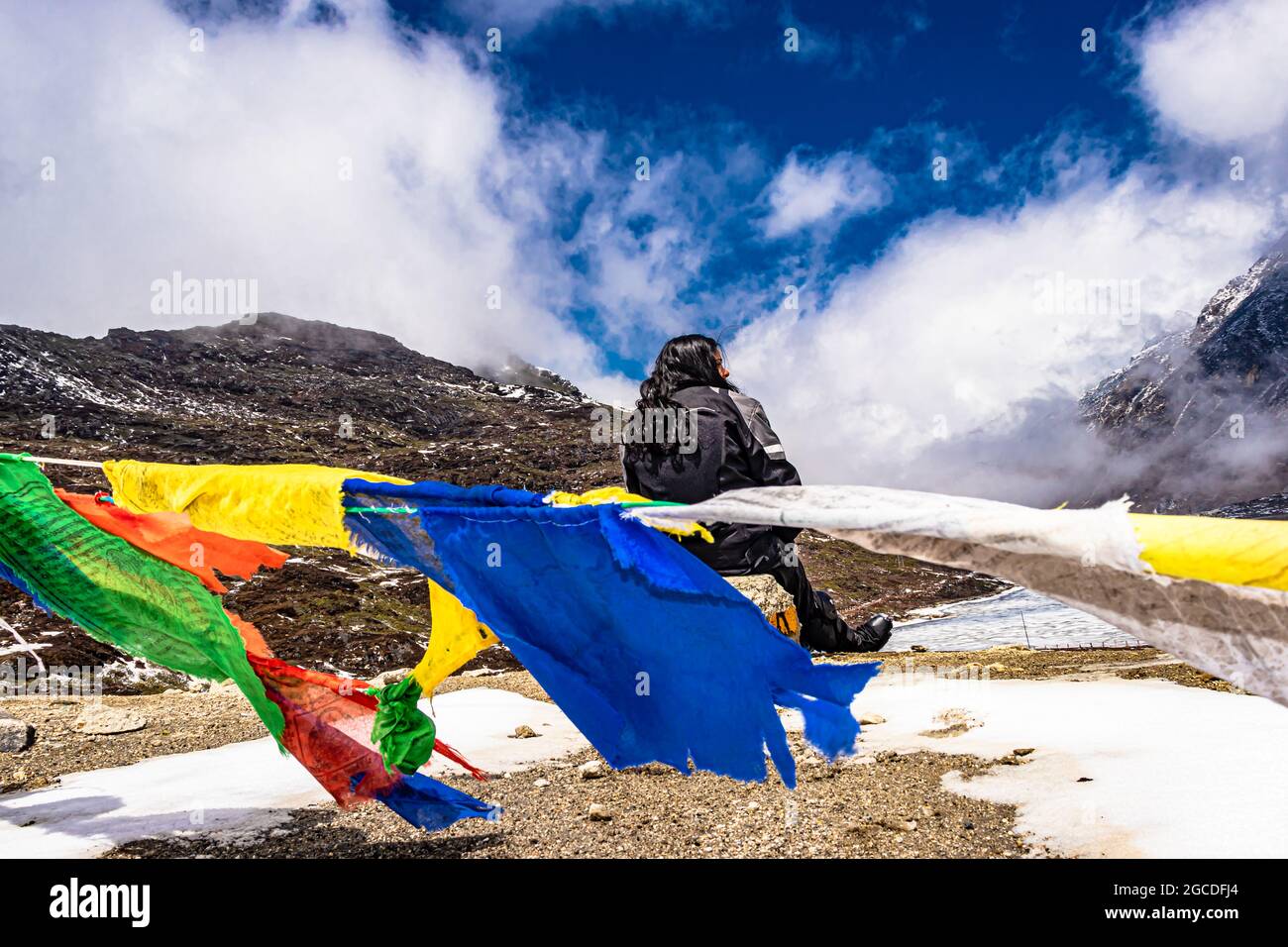 Giovane ragazza isolata in cima alla montagna con bandiere buddhiste al giorno immagine è presa al passo di sela tawang arunachal pradesh india. Foto Stock