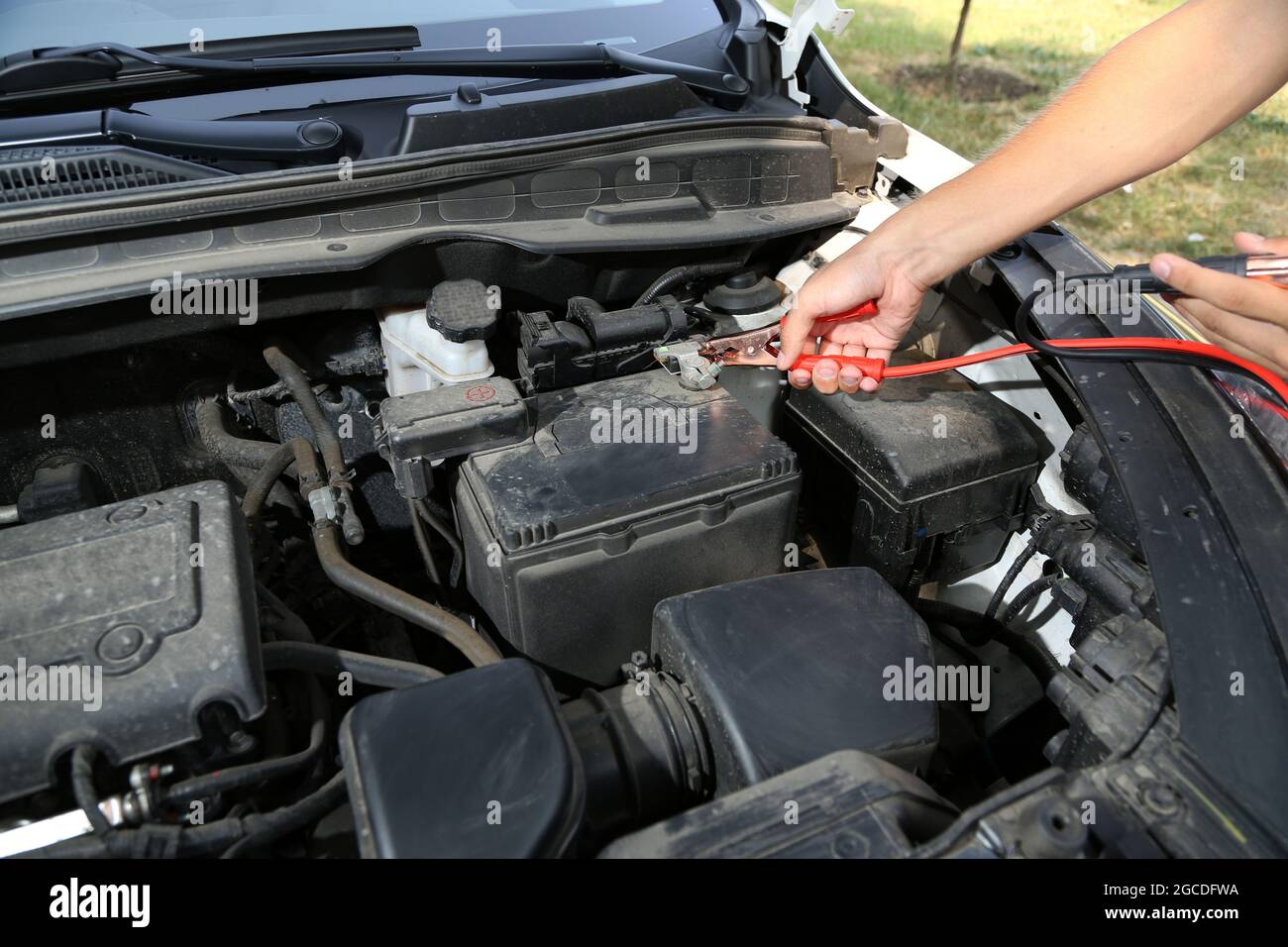 Il meccanico dell'auto utilizza i cavi di collegamento della batteria per  caricare la batteria scarica Foto stock - Alamy