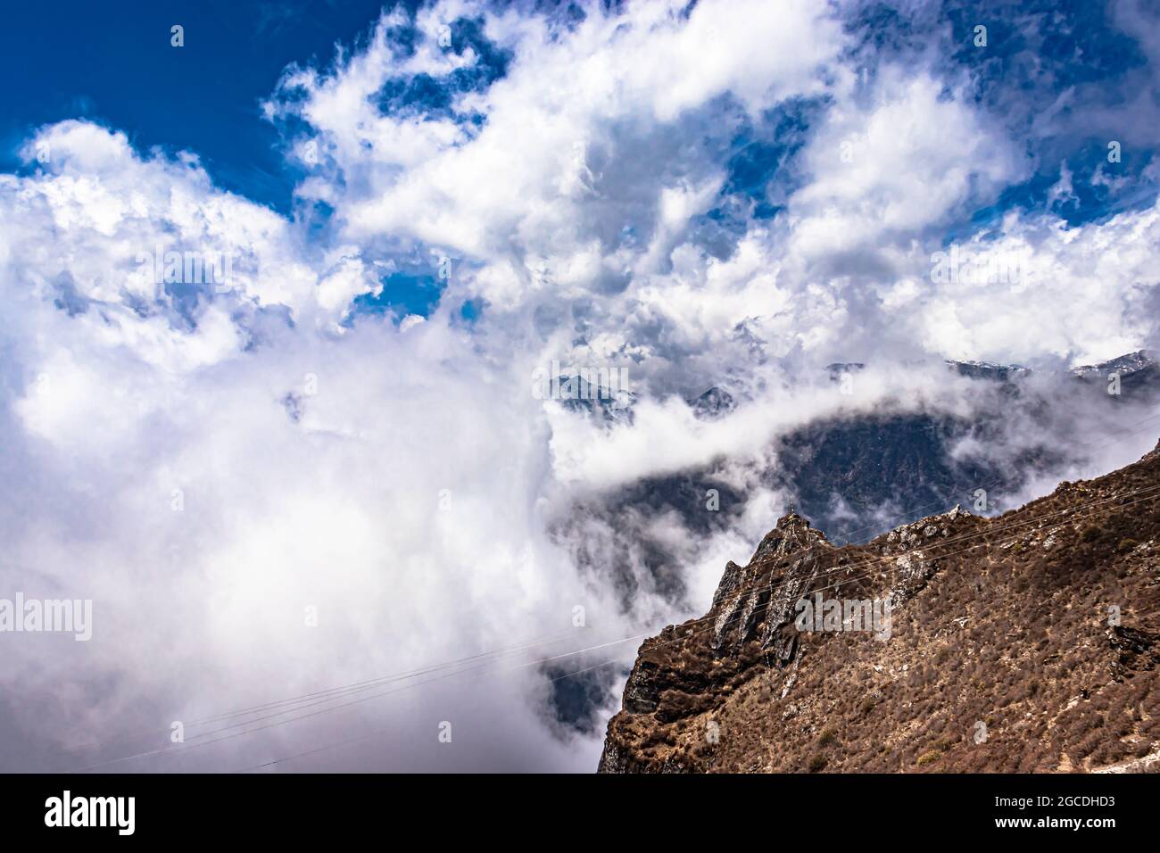 montagna con macchie nuvolose e cielo blu al mattino da un'immagine ad angolo piatto è preso al passo di sela tawang india. Foto Stock