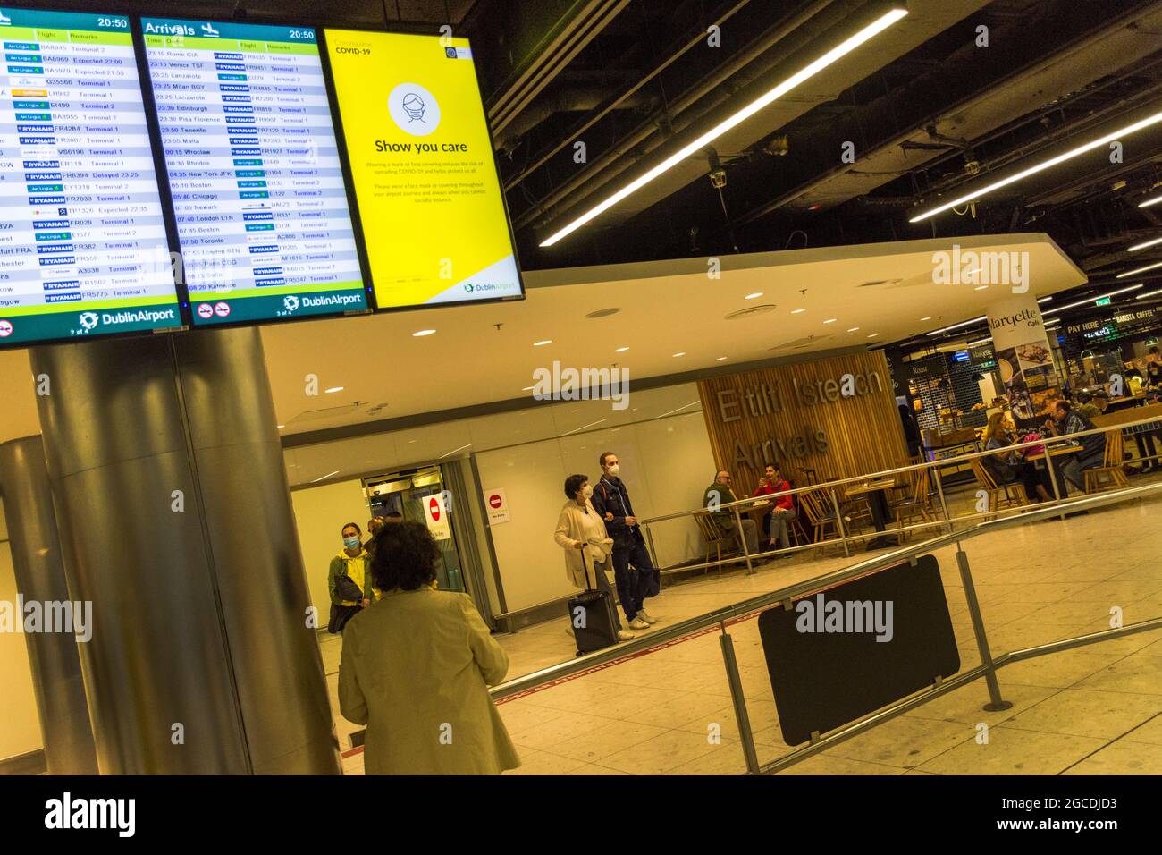 I passeggeri che indossano maschere arrivano all'aeroporto di Dublino, terminal 1, durante la pandemia di Covid19, Irlanda. Foto Stock
