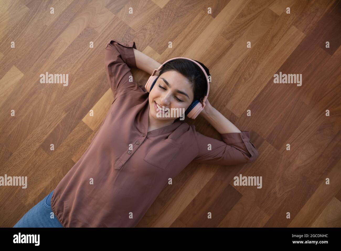 Felice donna indiana ascoltare la musica negli auricolari Foto Stock