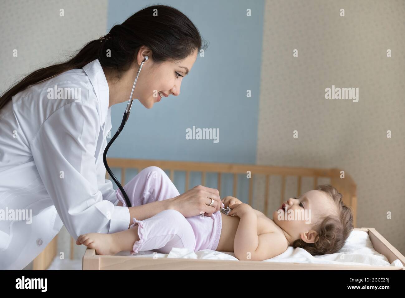 Cura medico femminile esamina il bambino piccolo in ospedale Foto Stock