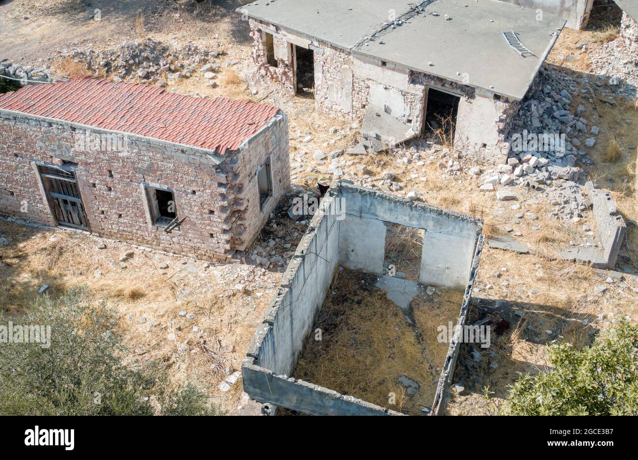 Rovine di vecchie case con muri rotti e tetto in villaggio abbandonato, vista dall'alto Foto Stock