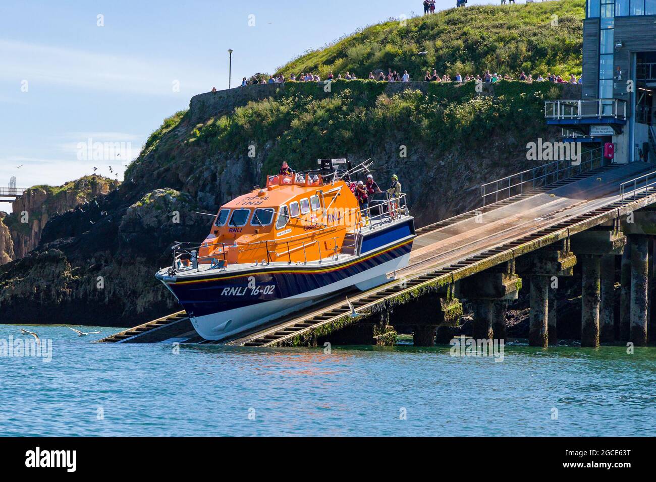 TENBY, GALLES - GIUGNO 15 2021: Il battello di salvataggio offshore classe Tamar RNLI 'Haydn Miller' viene lanciato dallo scivolo presso la stazione di scialuppa di salvataggio nella stoppa del resort Foto Stock