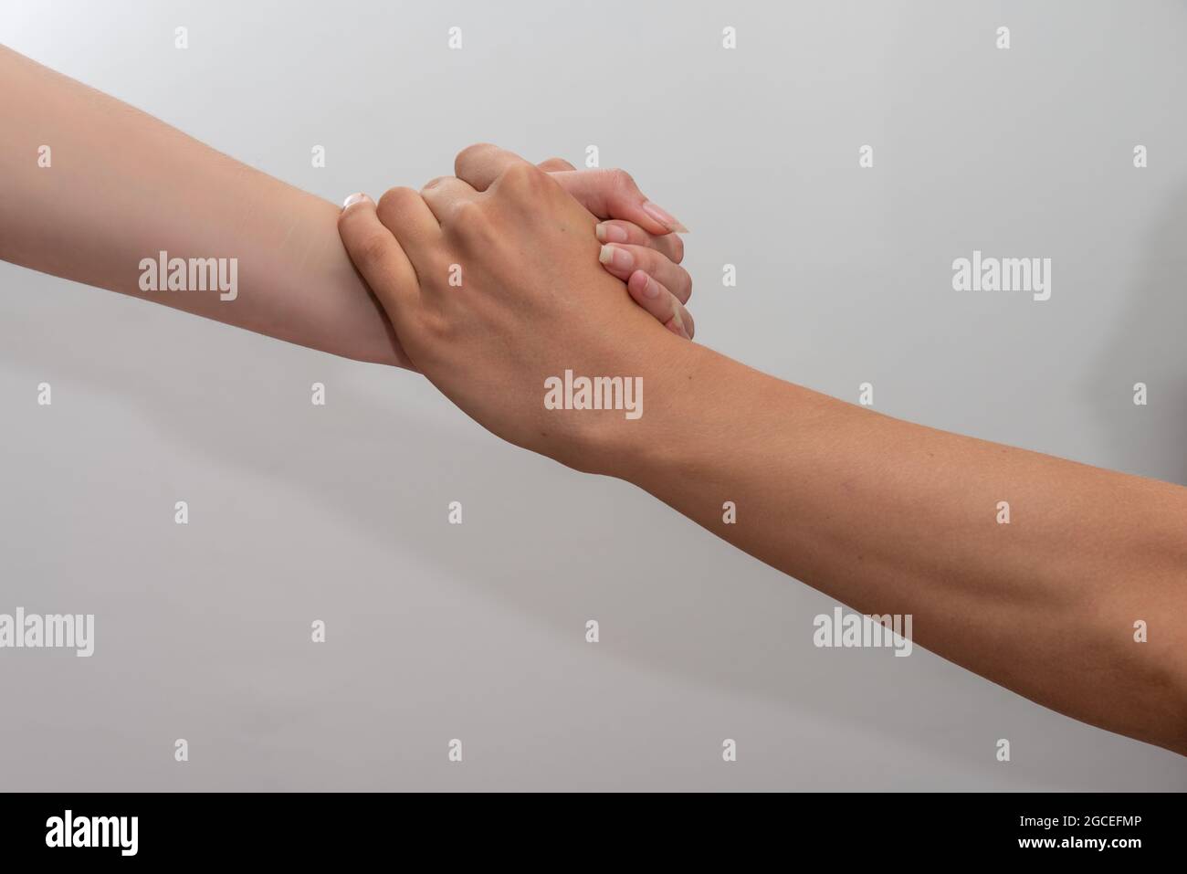 aiutare le mani uomo e donna che tengono le mani su sfondo bianco concetto di partnership e lavoro di squadra . Foto Stock