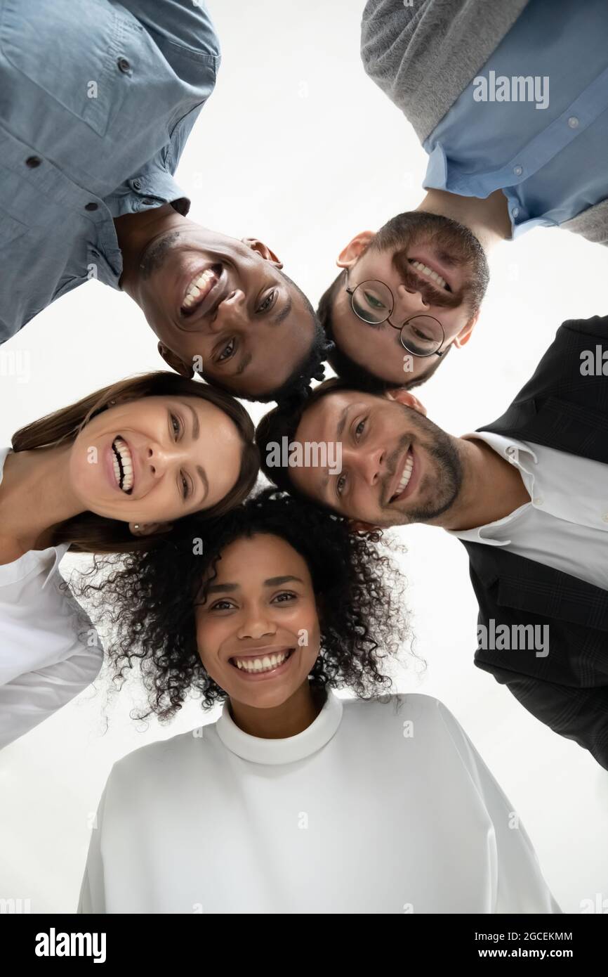 Ritratto ad angolo basso di sorridenti dipendenti diversi insieme Foto Stock