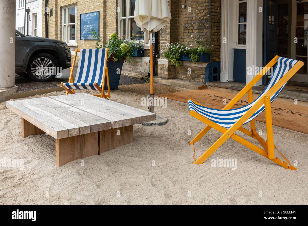 Il Grosvenor Hotel nella città Hampshire di Stockbridge, Inghilterra, Regno Unito, con sedie a sdraio e finta spiaggia di sabbia nel portico anteriore, staycation 2021 Foto Stock