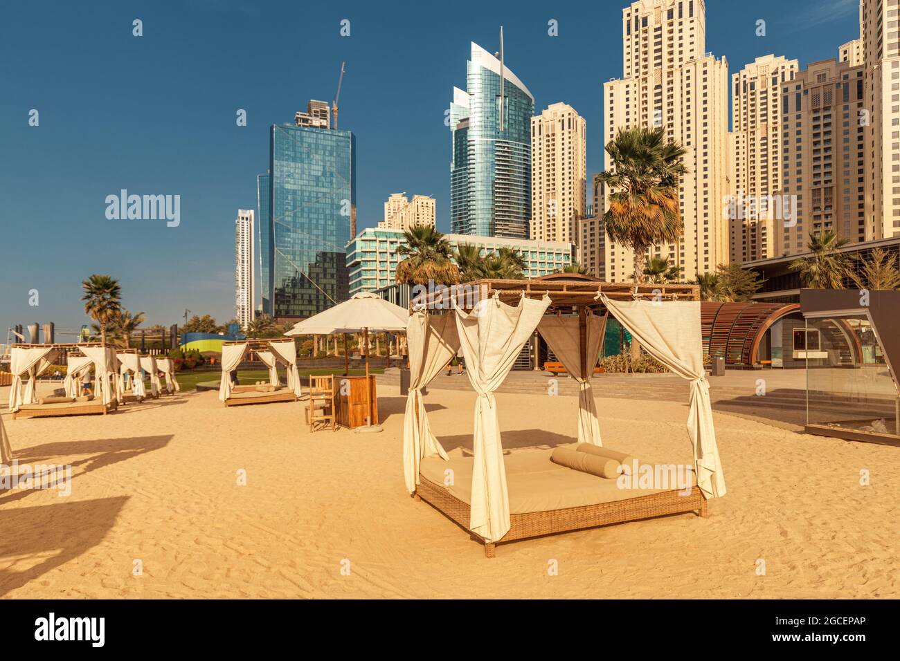 Baldacchino con tende e lettini prendisole in attesa di turisti in Dubai Jumeirah Beach resort. Concetto di vacanza di lusso Foto Stock
