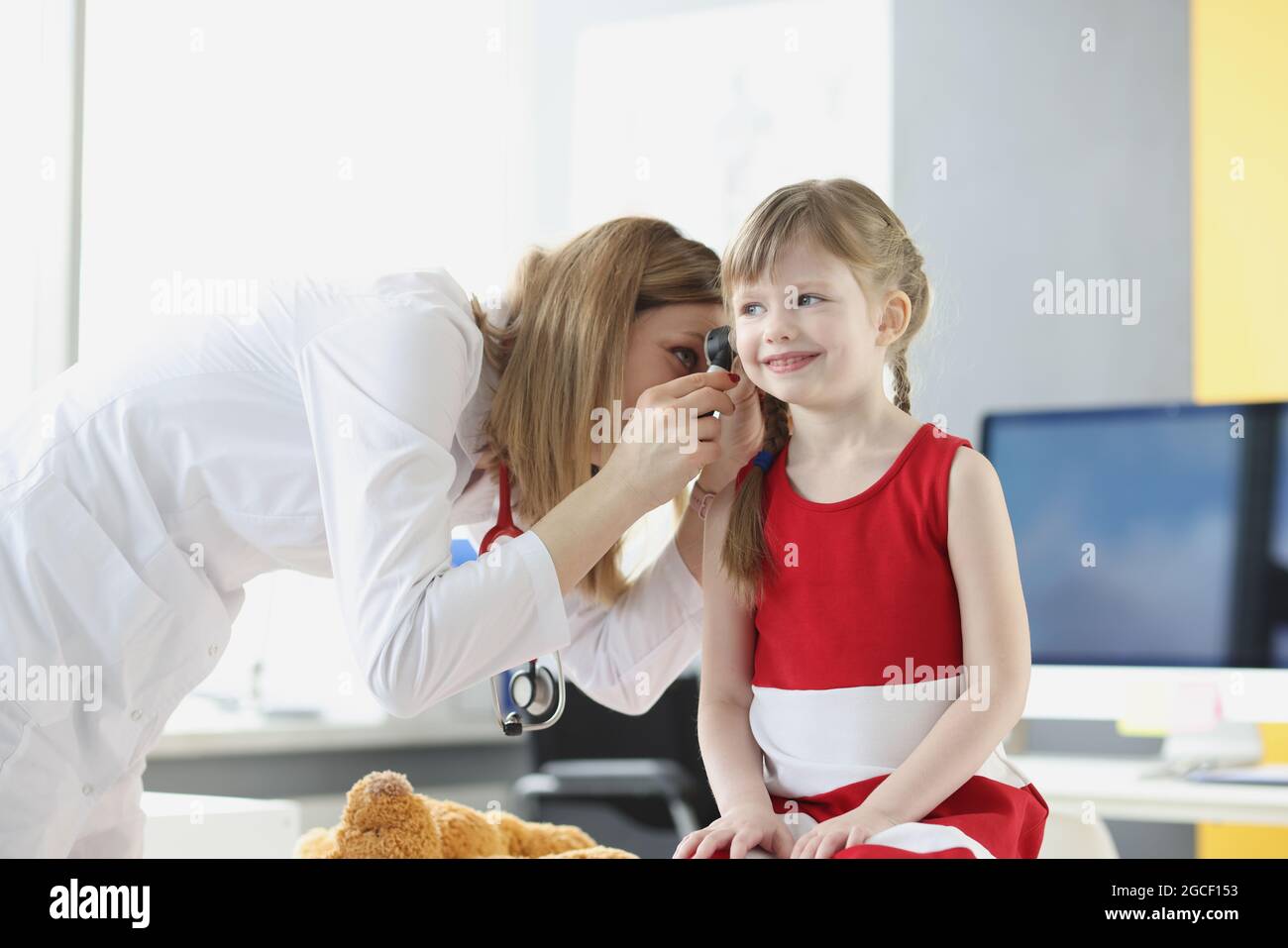 Il medico esamina le orecchie del bambino con un otoscopio nel closeup dell'ufficio del medico Foto Stock