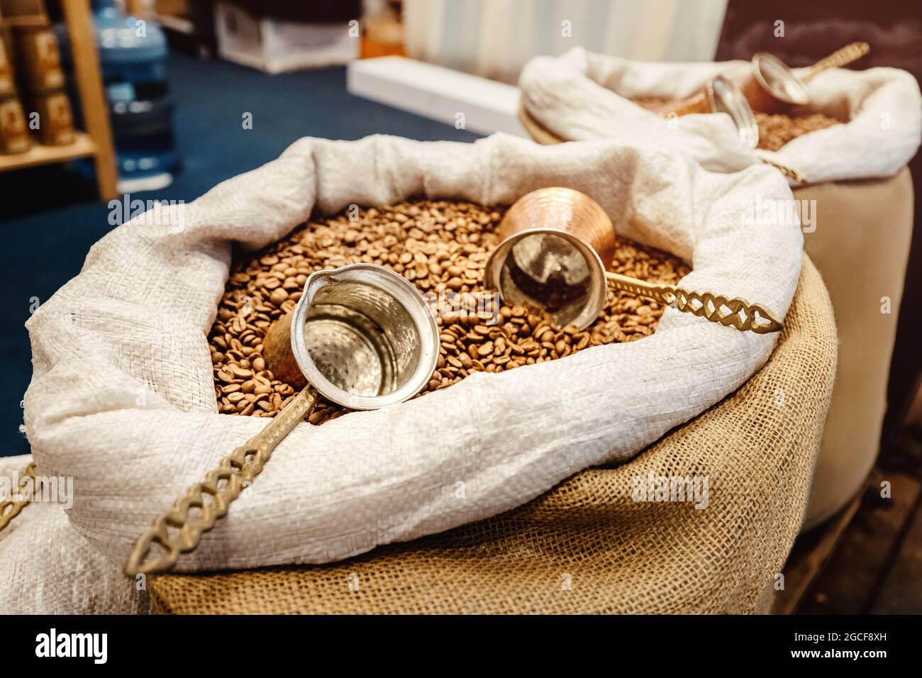 I chicchi di caffè e una macchina per il caffè turco cezve si trovano in una borsa di tela. Il concetto di una bevanda profumata e la sua raccolta Foto Stock