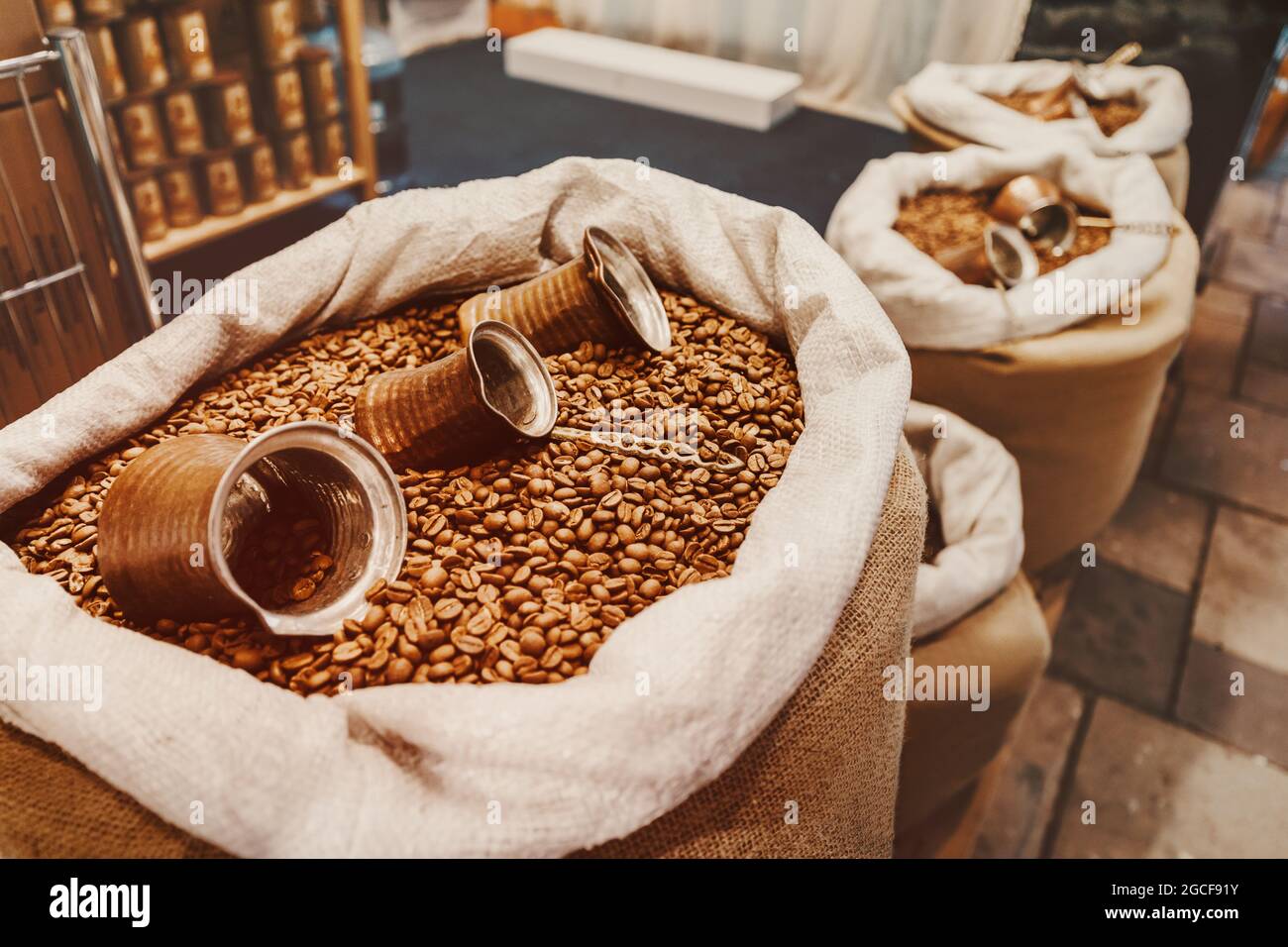 I chicchi di caffè e una macchina per il caffè turco cezve si trovano in una borsa di tela. Il concetto di una bevanda profumata e la sua raccolta Foto Stock
