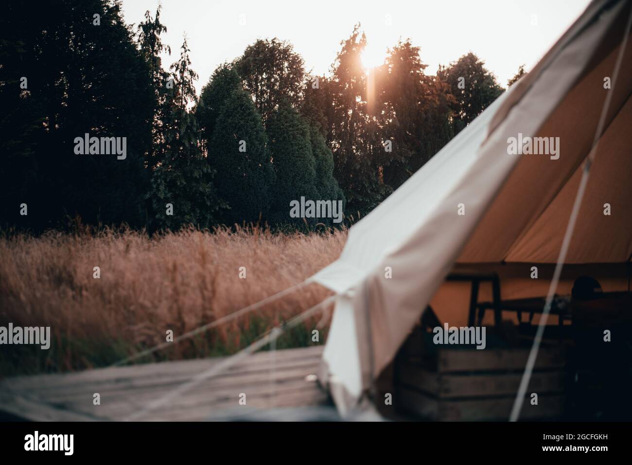 All'interno di una tenda campanaria usata per glamping e campeggio in un  lungo campo d'erba con il tramonto dietro la tenda Foto stock - Alamy