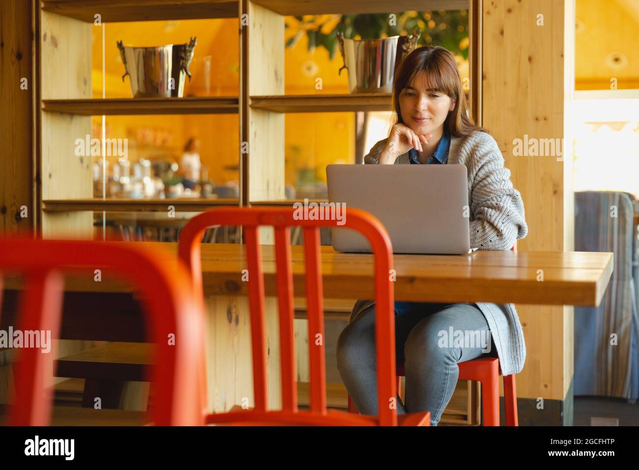 Donna al lavoro su un computer portatile su un comodo spazio Foto Stock