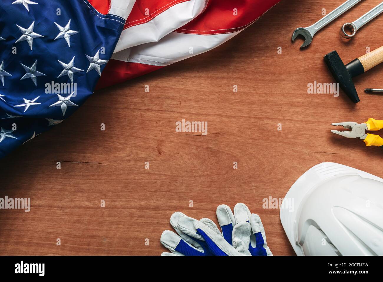 Concetto American Labor Day, vista dall'alto piatto con bandiera USA e utensili su scrivania in legno, direttamente sopra Foto Stock