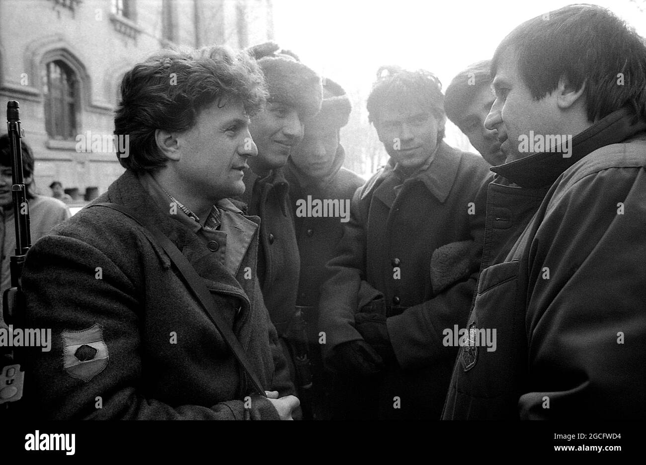 Bucarest, Romania, gennaio 1990. L'attore George Mihaita parla con i soldati per le strade nei giorni osceni subito dopo la caduta del comunismo. Foto Stock