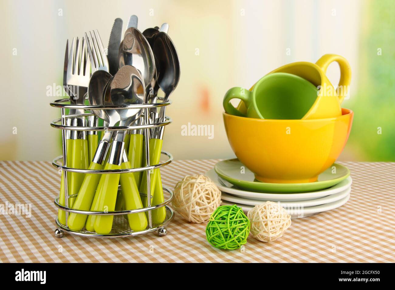 Posate da cucina in supporto metallico con piatti puliti su tovaglie su  sfondo luminoso Foto stock - Alamy