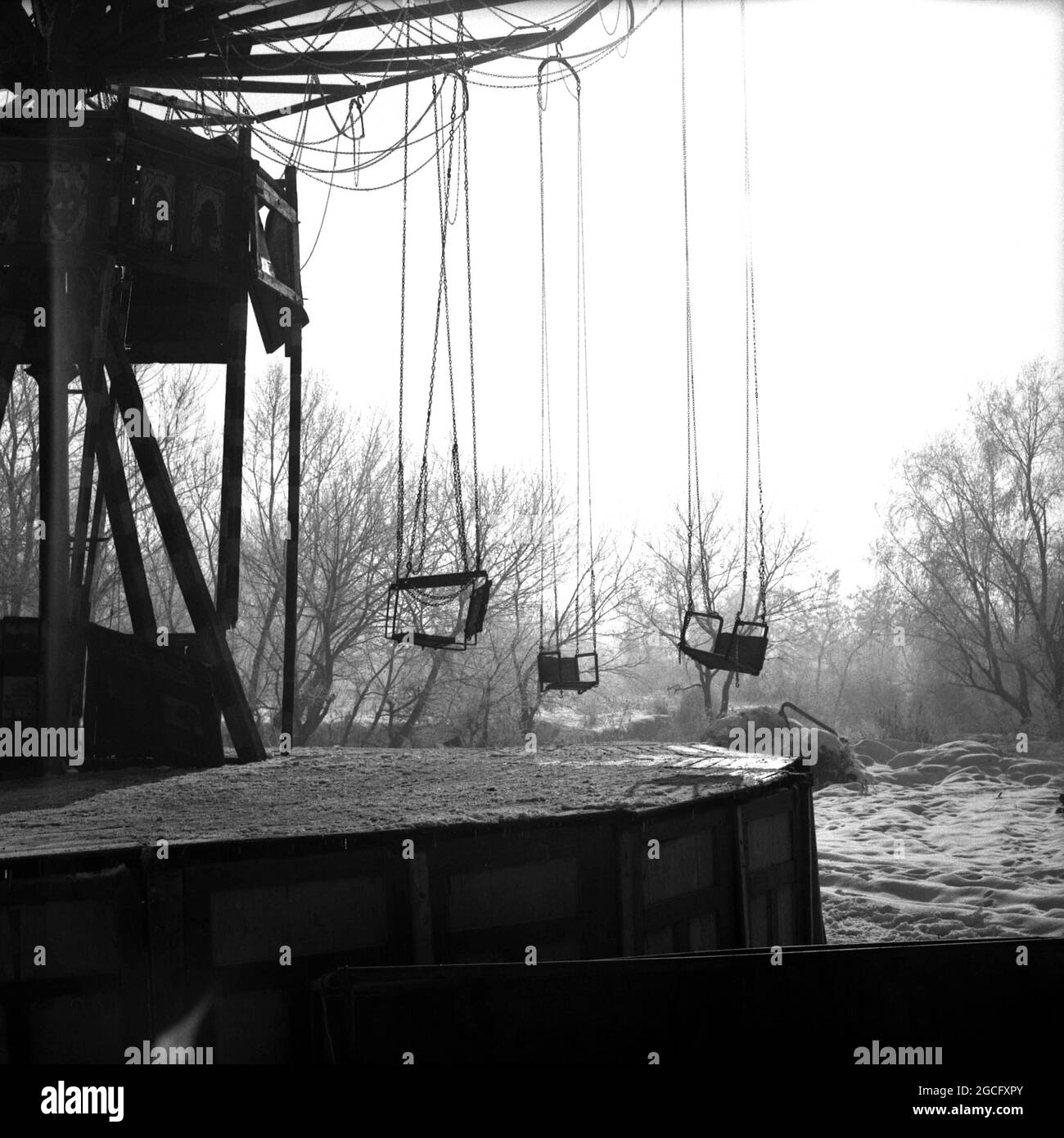 Parco Herăstrău, Bucarest, Romania, circa 1975. Vecchio carosello a catena allegro-go-round in una giornata invernale. Foto Stock