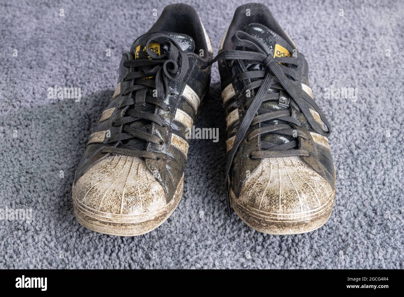 Praga, CZ - 08 Agosto 2021: Adidas Sneakers bagnato vecchio e sporco usato  punta nera di scarpe sportive in fango e suolo. Scarpe dopo il gioco.  Editoriale Foto stock - Alamy