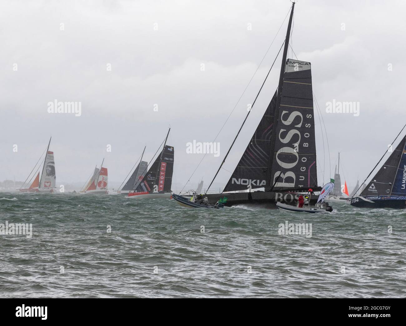 Cowes Isle of Wight, Regno Unito. 8 agosto 2021. Rolex Fastnet; Hugo Boss , IMOCA 60 in testa fuori dal Solent in 35 nodi di vento all'inizio della Fastnet Race. Credit Gary Blake /Alamy Live News Foto Stock