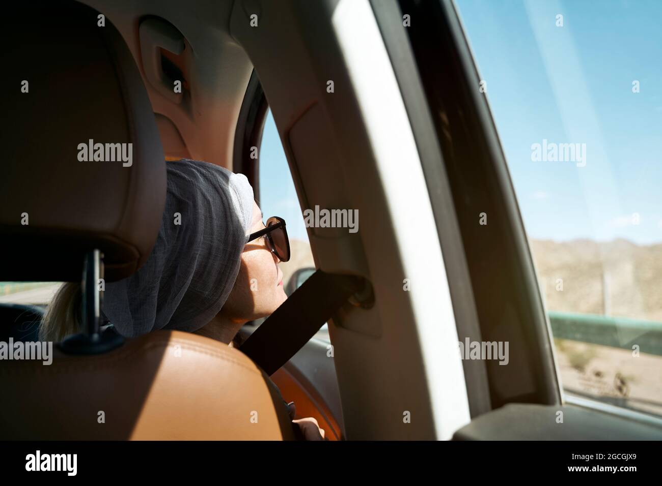 una donna asiatica che guarda la vista mentre si viaggia in auto Foto Stock