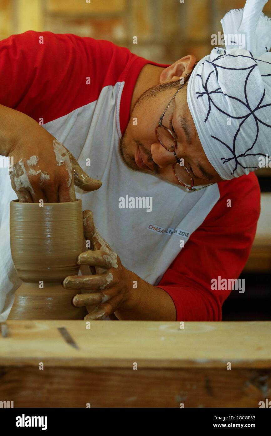 19 aprile 2019-Mungyeong, Corea del Sud-Corea Potter Chang Dong su fare ceramica a mano tazza di ceramica moderna usare l'argilla al suo proprio caffè 'Jang Choon' esperienza ceramica a Mungyeong, a sud di Seoul, Corea del Sud. Grande evento di ceramica sudcoreana Mungyeong Chasabal Festival che si tiene dal 27 aprile al 6 maggio 10 giorni di calendario ogni anno. Foto Stock