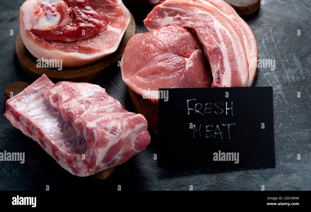 Diversi tipi di carne cruda su fondo nero. Alimenti ad alto contenuto proteico. Foto Stock