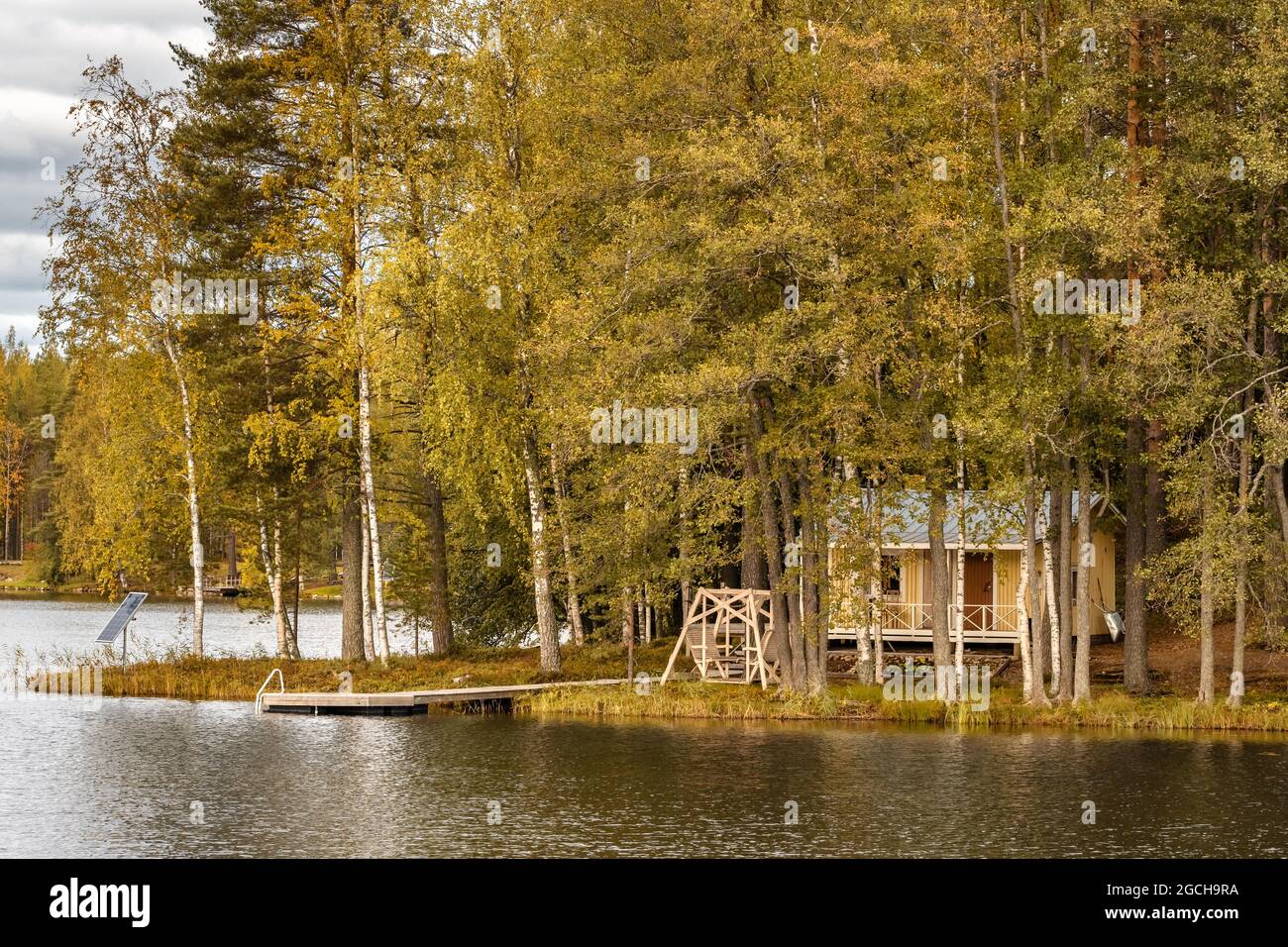 Piccola isola sul lago con una casa di campagna in Finlandia. Foto Stock