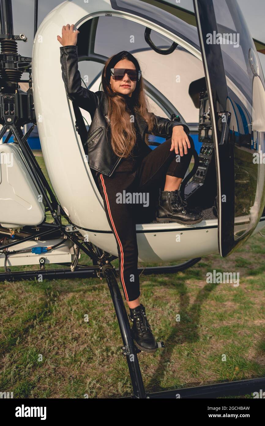 Presteen ragazza in occhiali da sole in piedi sulla pedana di elicottero Foto Stock