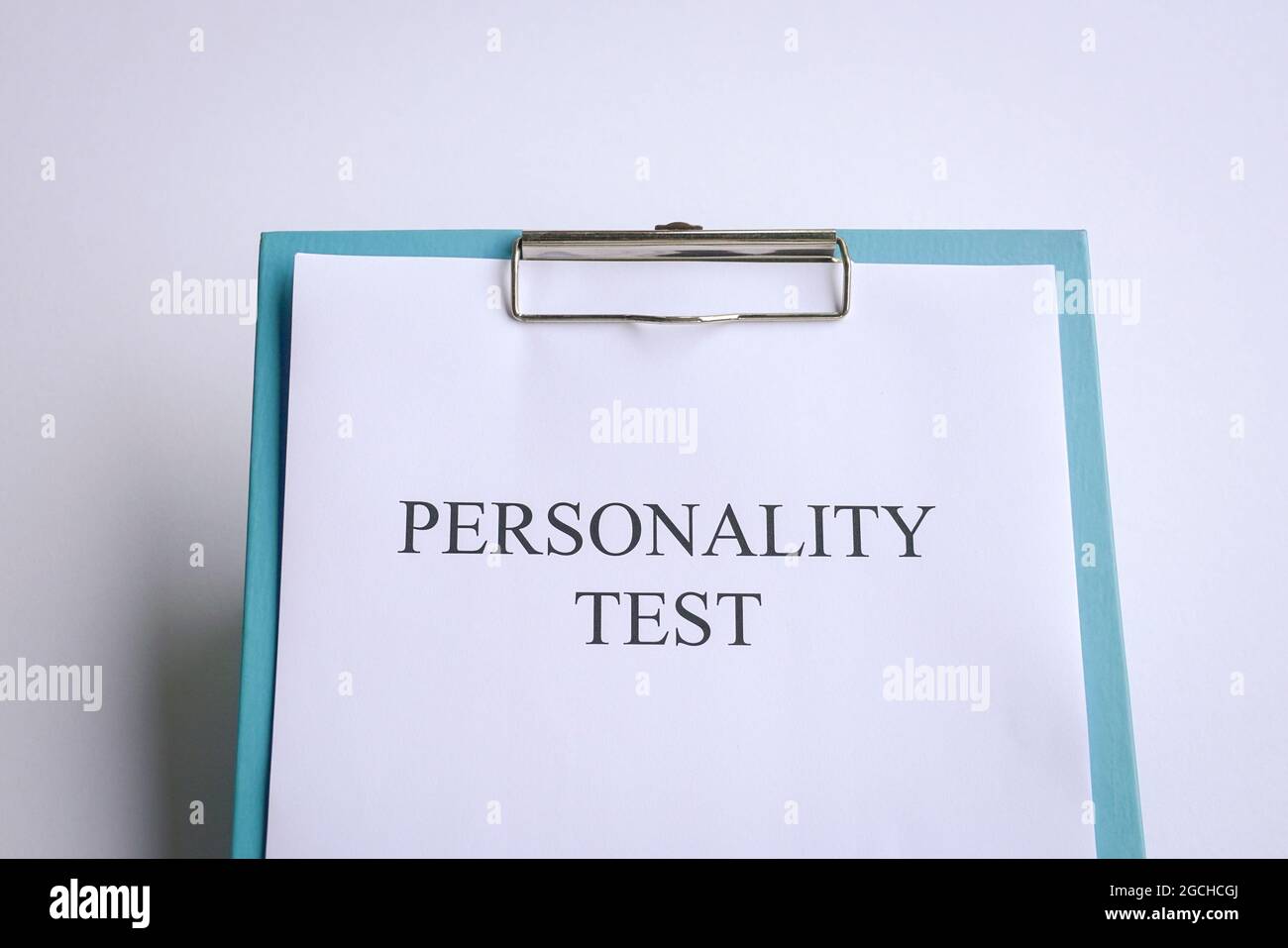 Test di personalità su clipboard blu, su piano portapaziente bianco. Foto Stock
