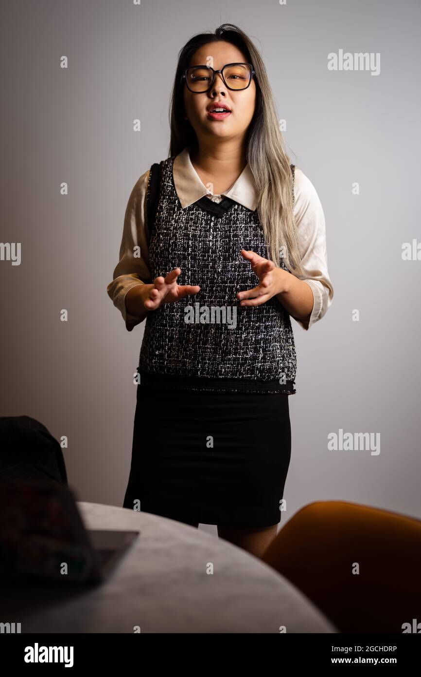 Giovane scienziata asiatica di dati che presenta i dati di analisi in una sala conferenze Foto Stock